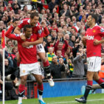 Chicharito salta sobre la espalda de Nani, con Ryan Giggs a la derecha, durante un festejo de Manchester United en 2010