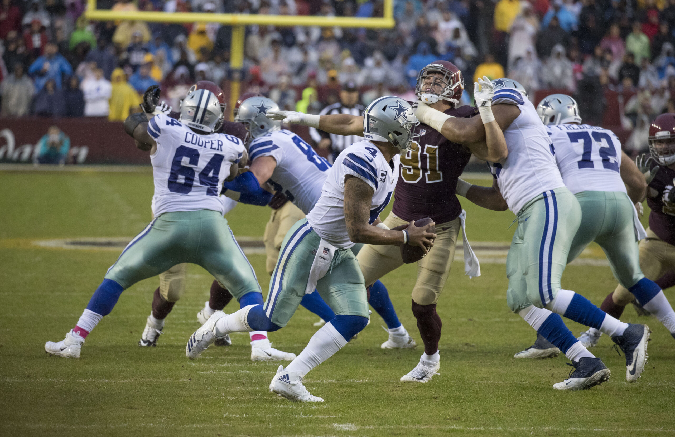 Dak Prescott sostiene el balón detrás de sus bloqueadores ante Washington en octubre de 2017