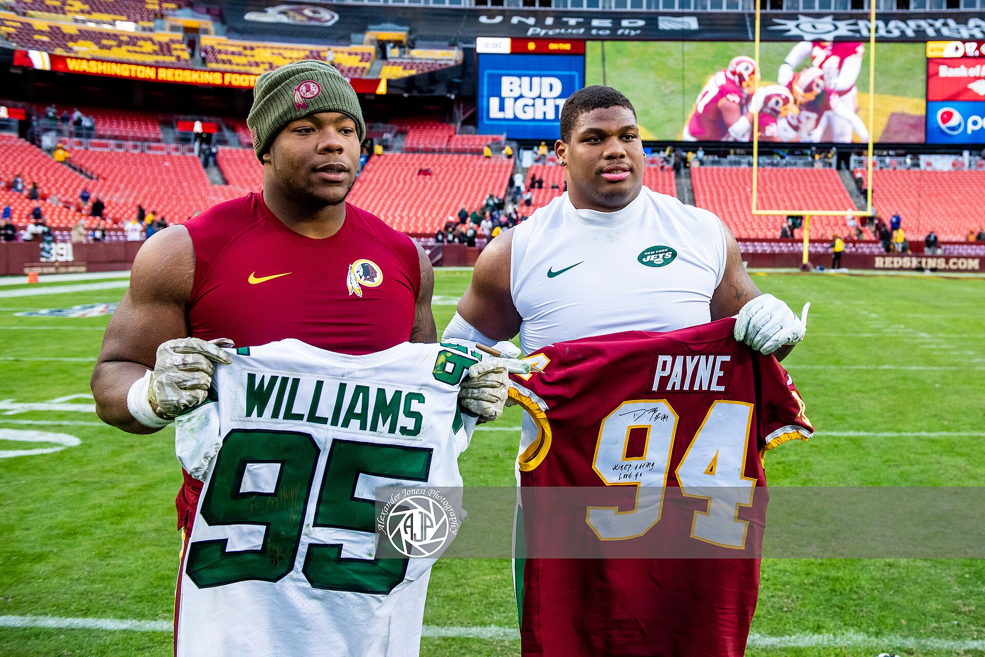 Quinnen Williams, a la derecha con camiseta blanca de los Jets, posa con Daron Payne tras intercambiar camisetas en noviembre de 2019