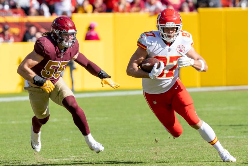 Travis Kelce corre con el balón mientras Cole Holcomb lo persigue durante un partido de octubre de 2021
