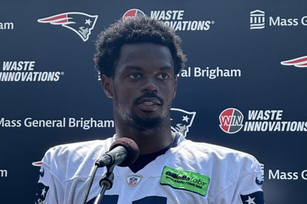 Tyquan Thornton responde preguntas ante un micrófono con el uniforme de Patriots en julio de 2023