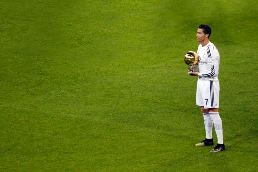 Cristiano Ronaldo sostiene su Balón de Oro de 2014 sobre el césped del Santiago Bernabéu